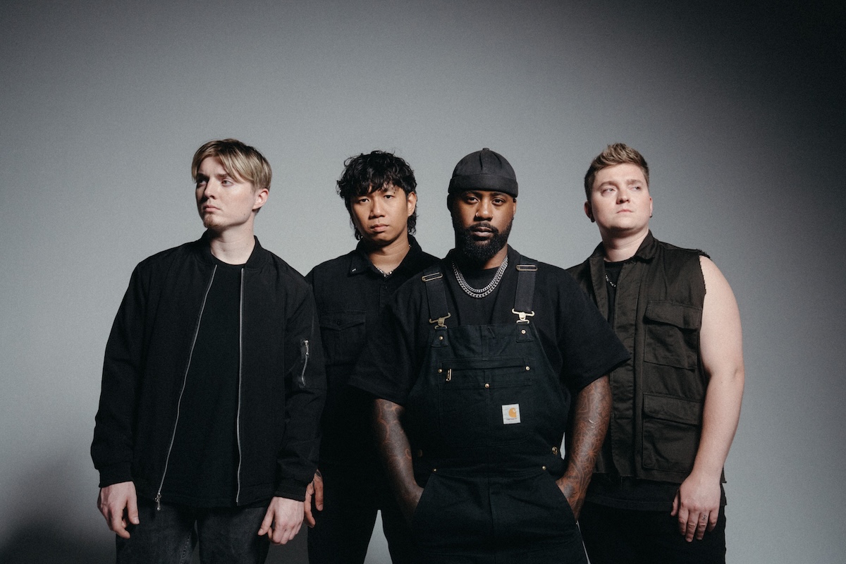 Rock band Sleep Theory standing together in dark casual outfits posing against a plain gray studio backdrop.